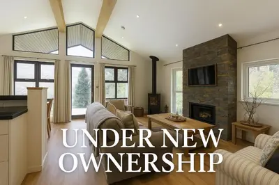 a living room with a couch and a fireplace at Sixpenny Bay in Morenish