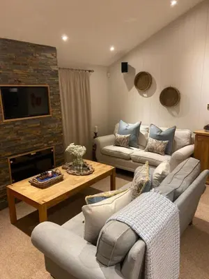 a living room with two couches and a table at Sixpenny Bay in Morenish