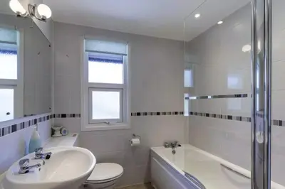 a bathroom with a sink and a tub and a toilet at Sixpenny Bay in Morenish