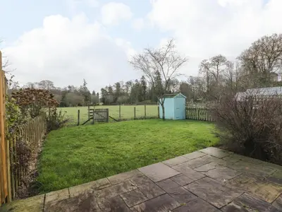 a yard with a fence and a field at The Stables in Dumfries