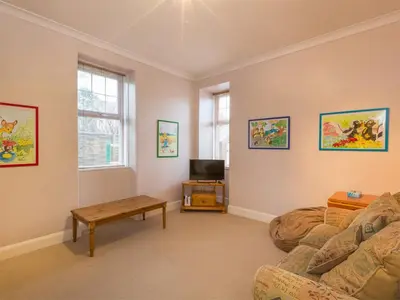 a living room with a couch and a table at 5 Bed in Brodick CA016 in Brodick