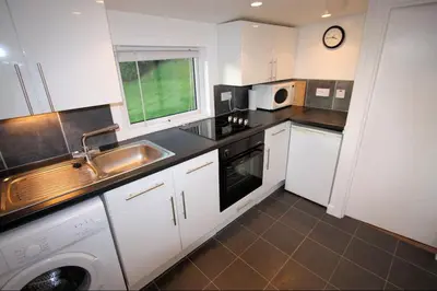 a small kitchen with a sink and a microwave at Ellary Cottage in Stonefield