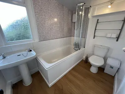a bathroom with a tub and a toilet and a sink at The Lodge in Lochgilphead