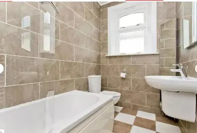 a bathroom with a tub and a toilet and a sink at Tigh Lochlainn in Prestwick