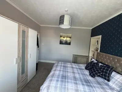 a bedroom with a bed with a checkered blanket at Tigh Lochlainn in Prestwick