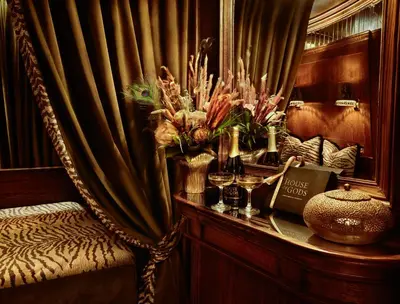 a room with a chair with a table with flowers at House of Gods Glasgow in Glasgow