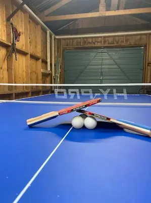 two tennis rackets and balls on a blue table at Stunning Dalchenna w/hot tub & huge garden in Stirling
