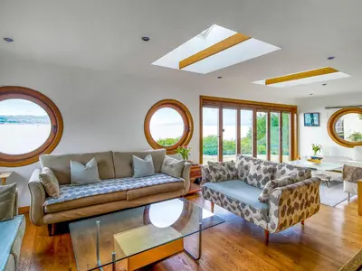 a living room with a couch and a table at Shore House in Kilcreggan