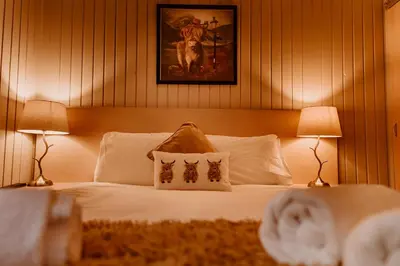 a bedroom with a white bed with two lamps at Whisky Whispers Hunters Quay in Sandbank
