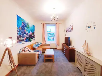 a living room with a couch and a table at The Octopus - at Largs Town Centre with Private Parking in Largs
