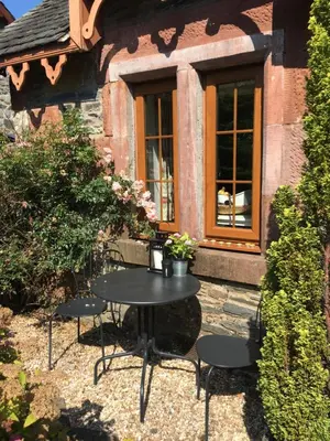 a table and chairs in front of a building at Alderdale B&B in Luss