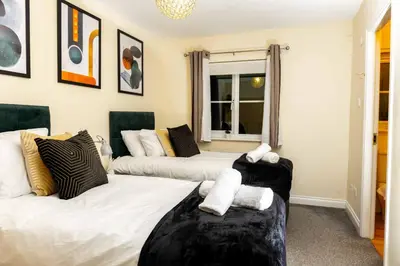 two beds in a room with paintings on the wall at Livingston North Station Apartments in Livingston