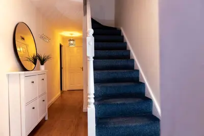 a staircase in a home with a blue carpet at Livingston North Station Apartments in Livingston