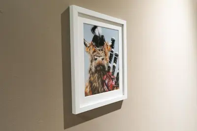 a picture of a giraffe hanging on a wall at Broom Cottage in Lanark