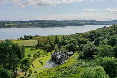 an aerial view of a house in a field next to a lake at Tarbert Country Manor in Tarbert