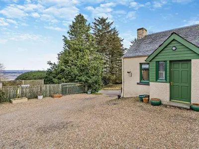 a house with a green door and a gravel driveway at 1 Bed in Dunning oc-ca333 in Dunning