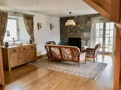 a living room with a couch and a fireplace at Bremenvoir Barn in Bunessan