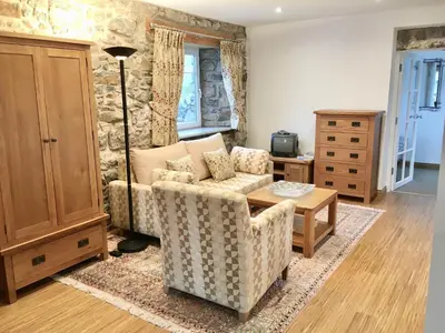 a living room with a couch and a table at Bremenvoir Barn in Bunessan