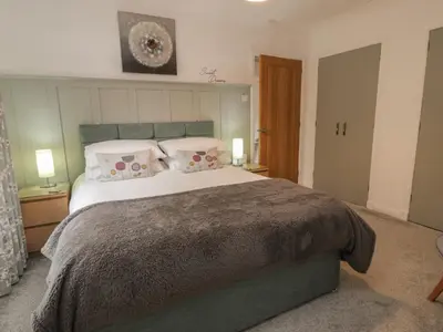 a bedroom with a large bed with two pillows at Hollys Hideaway in Castle Douglas