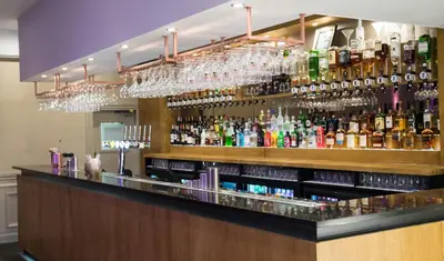 a bar with a lot of bottles of alcohol at The Parkville Hotel in Hamilton