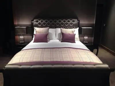 a bedroom with a large bed with purple pillows at The Parkville Hotel in Hamilton