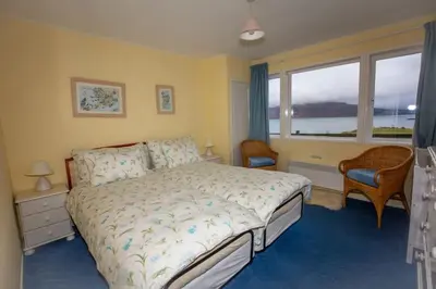 a bedroom with a bed and a window at Ormsaig Wooden Cottage in Burgh