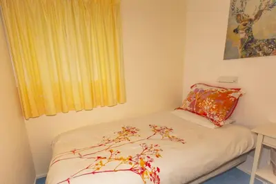 a small bedroom with a bed with a tree on it at Ormsaig Wooden Cottage in Burgh