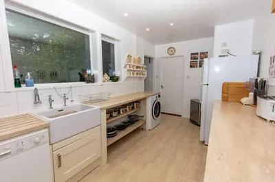 a kitchen with a sink and a refrigerator at Ormsaig Wooden Cottage in Burgh