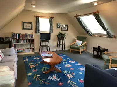 a living room with a couch and a table at Stable Cottage, Ardnadrochet in Lochdon