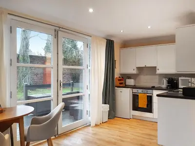 a kitchen with white cabinets and a table and a window at Leven Lodge 1 - Uk46042 in Balloch