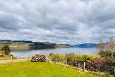 a view of a body of water with a fence at The Cottage, overlooking Loch Fyne in Cairndow