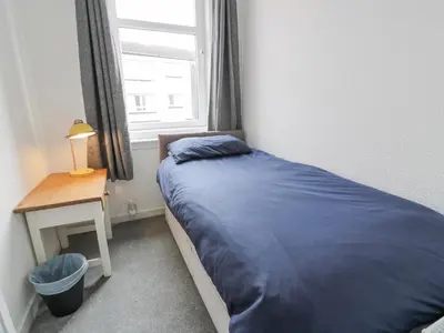 a small bedroom with a bed and a window at Little Ireland in Stranraer