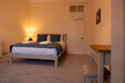 a bedroom with a bed and a desk with a lamp at Saskatchewan House in Oban