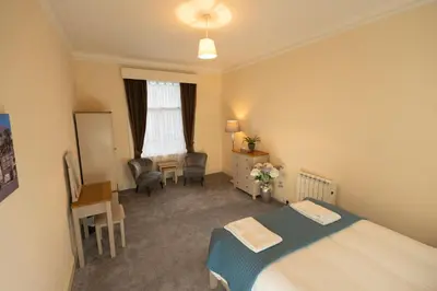 a bedroom with a bed and a desk and a table at Saskatchewan House in Oban