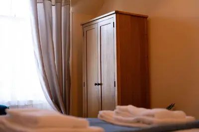 a bedroom with a cabinet and a pile of towels at Saskatchewan House in Oban