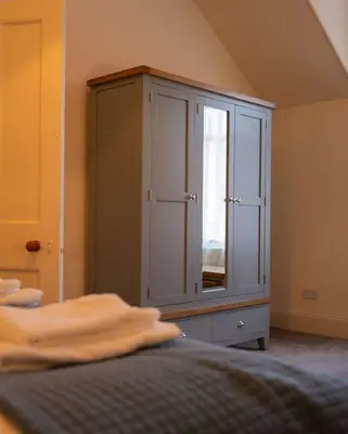 a bedroom with a large cabinet with a mirror at Saskatchewan House in Oban