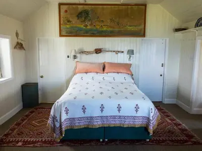 a bedroom with a bed with a comforter on it at Archie's Cottage in Auchnacraig