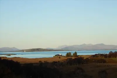a view of a lake with mountains in the background at Archie's Cottage in Auchnacraig