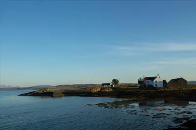 a house on a small island in the water at Archie's Cottage in Auchnacraig