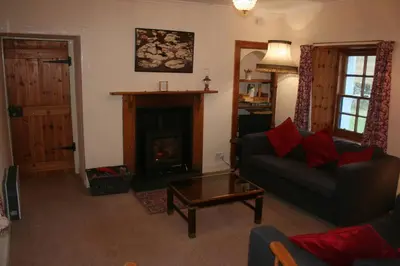 a living room with a couch and a fireplace at Barrachandroman Farmhouse in Lochbuie