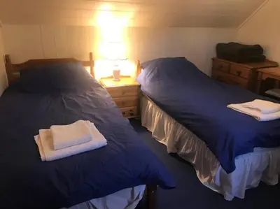 two beds sitting next to each other in a bedroom at Barrachandroman Farmhouse in Lochbuie