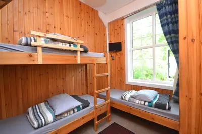 a room with two bunk beds and a window at Blackwater Hostel in Kinlochleven