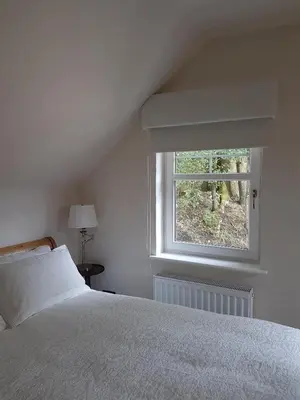a bedroom with a white bed and a window at Station House Lanark Bed and Breakfast in Lanark
