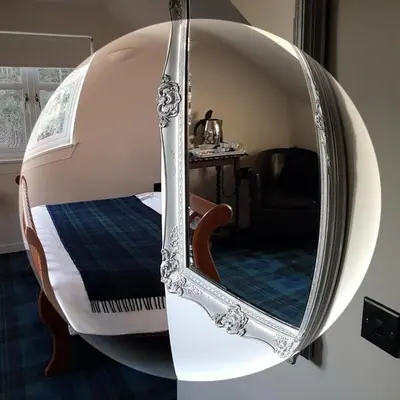 a room with a bed and a round mirror at Station House Lanark Bed and Breakfast in Lanark