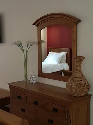 a mirror on top of a dresser with a bed at Station House Lanark Bed and Breakfast in Lanark