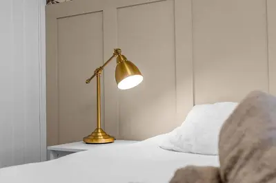 a gold lamp sitting on a bed in a bedroom at West Lothian 5 Beds + car space in Whitburn