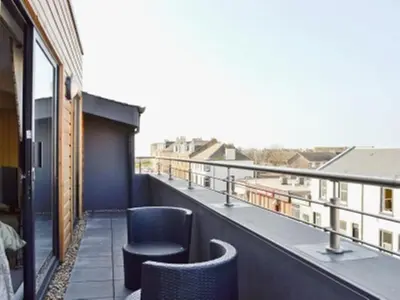 a balcony with chairs and a view of a building at The Penthouse- The Kingsley Collection in Troon