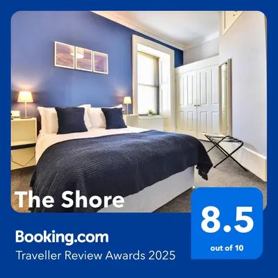 a bedroom with a bed with a blue wall at The Shore in Gourock