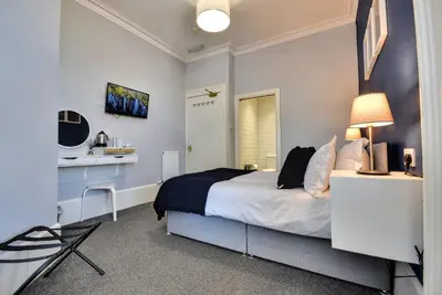 a bedroom with a bed and a sink in it at The Shore in Gourock
