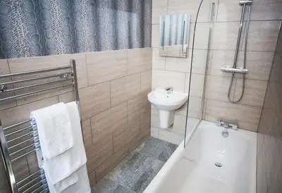 a bathroom with a shower and a toilet and a sink at Braid Hills Hotel in Edinburgh